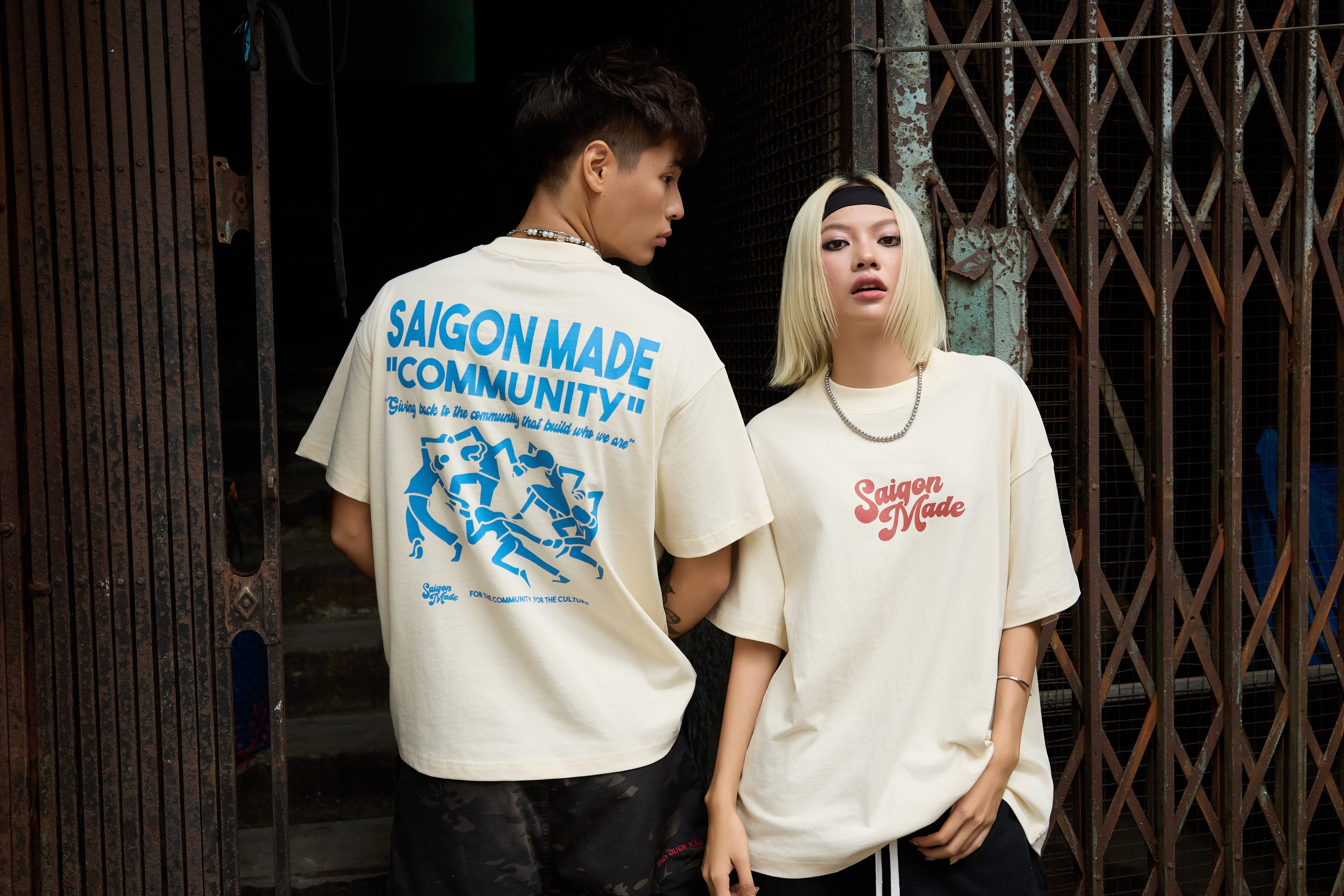 Two people wearing 'Saigon Made' t-shirts in an urban setting.