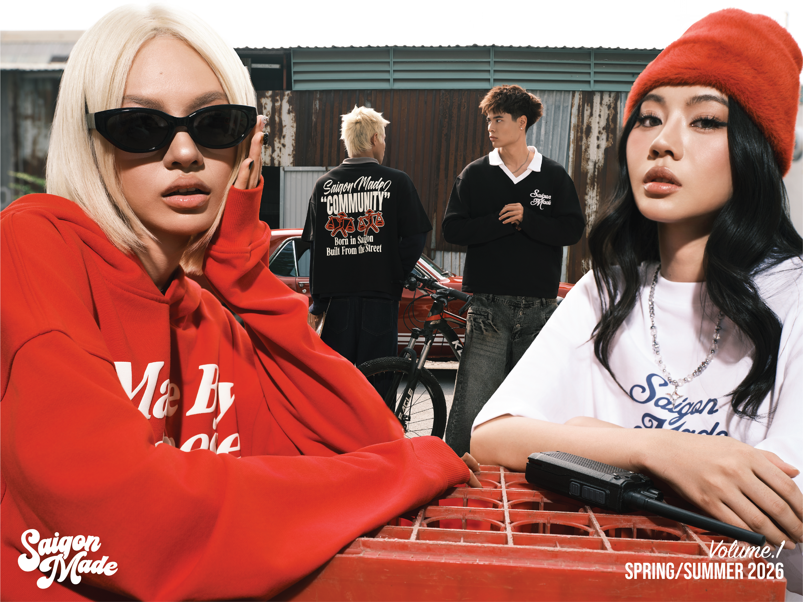 Two people sitting on a red bench with a third person standing in the background, featuring 'Saigon Mode' branding.