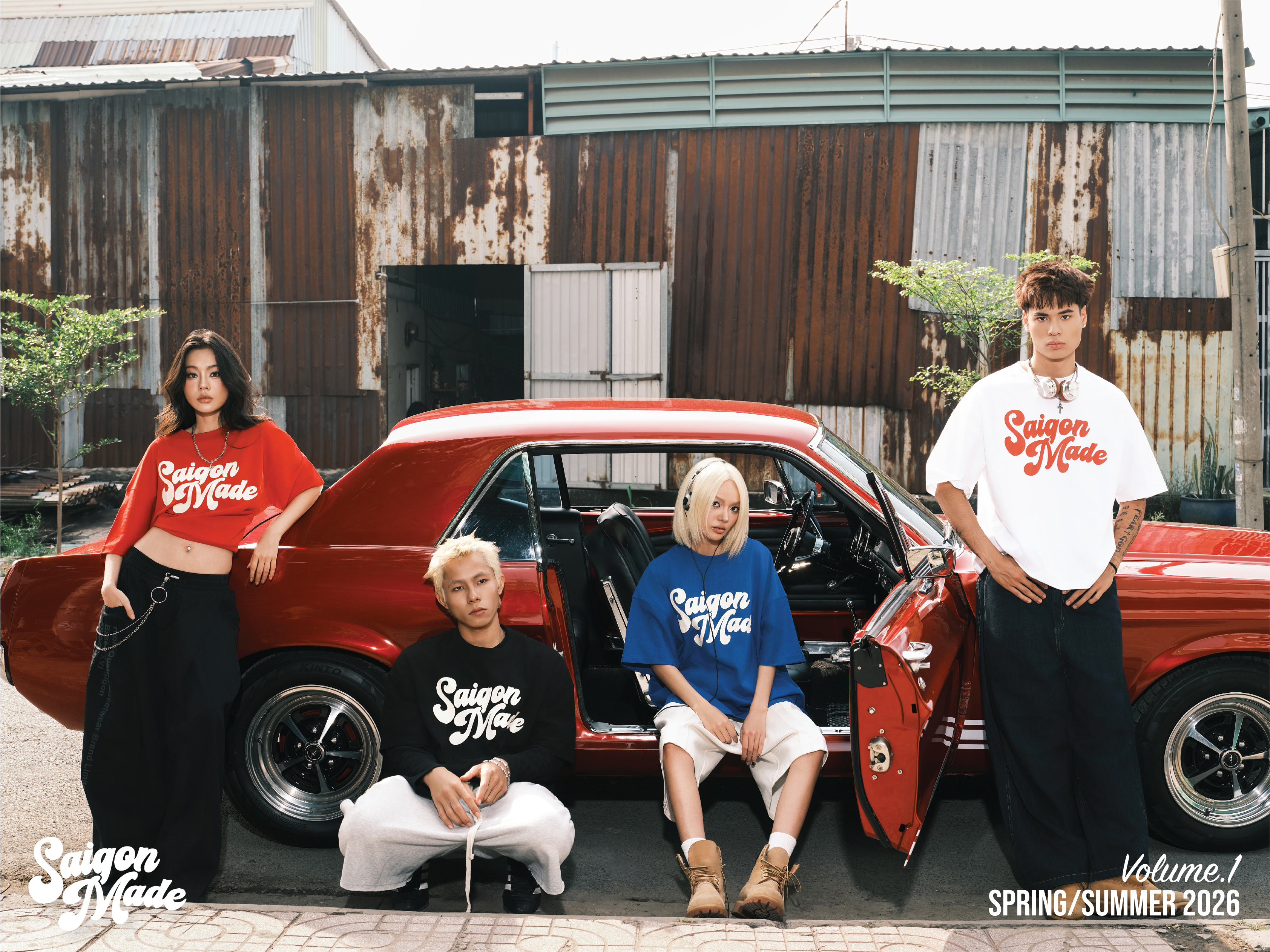 Four individuals standing in front of a red car with 'Saigon Made' branding.